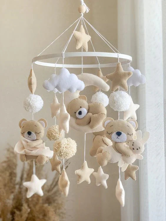 Handmade baby mobile with felt teddy bears, stars, and clouds in neutral beige tones for nursery room decor