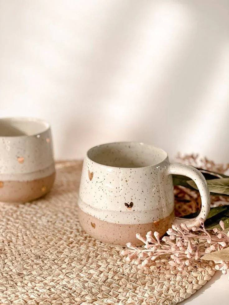 Handcrafted ceramic mug with heart design in beige and white tones, perfect for modern rustic kitchen décor