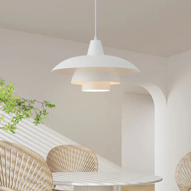 Modern white pendant lamp hanging above round dining table with rattan chairs in minimalist interior